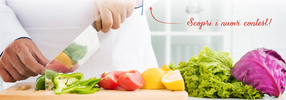 Chef che taglia verdure fresche colorate su un tagliere di legno